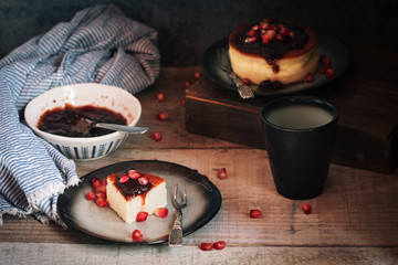 Cheesecake with berries jam and pomegranate in rustic plate