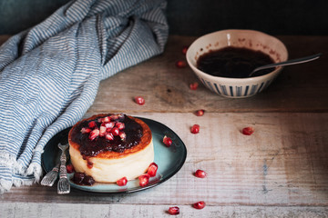 Cheesecake with berries jam and pomegranate in rustic plate