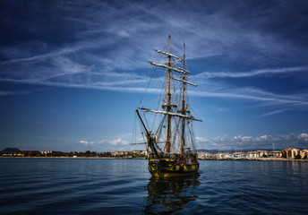 Old wooden sailing ship in the sea on summer day