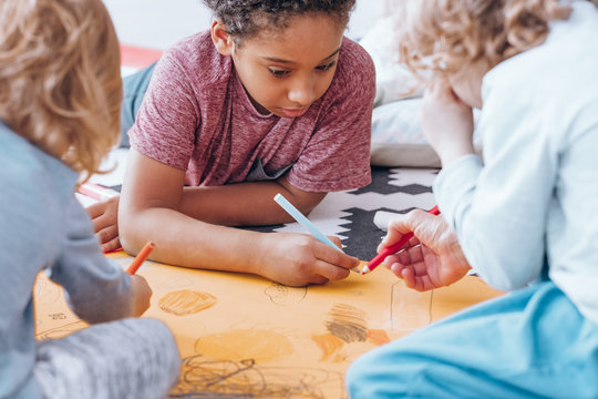 African-american boy drawing with classmate