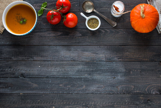 Homemade Pumpkin Soup on rustic wooden background, free space for text.