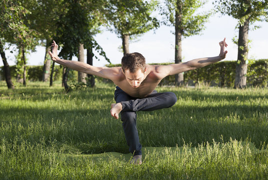 practice of yoga and gymnastics. young man in the park