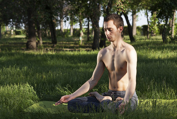  young man meditating in a lotus pose. practice of yoga. breathing exercises. practice of yoga.