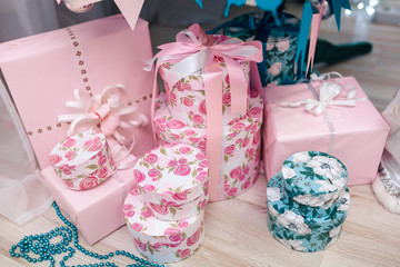 blue and pink decorated gift boxes with blue ribbon under decorated Christmas tree.