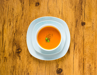 Homemade Pumpkin Soup on rustic wooden background, free space for text.
