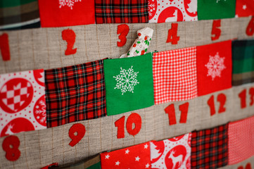 Fototapeta na wymiar Soft textile Christmas calendar with pockets on the wall