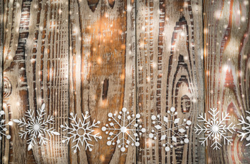 Paper snowflakes on wooden background .