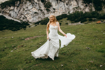 Smiled bride dancing in the Alps