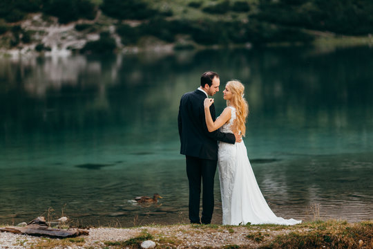 Beautiful wedding couple near the lake in the Alps