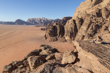Fototapeta na wymiar Reddish sand and rock landscapes in the desert of Wadi Rum, southern Jordan