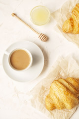  French breakfast with fresh croissants, raw honey and cappuccino. 