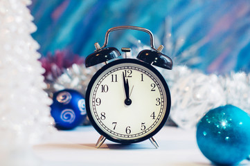 New Year alarm clock on a silver and blue background. New Year and Christmas decoration. Midnight.