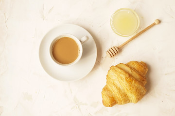  French breakfast with fresh croissants, raw honey and cappuccino. Top view.