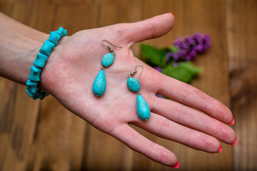 Bracelet and earrings of turquoise on a woman's palm.