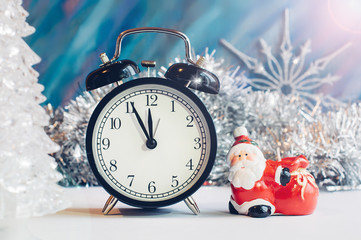 New Year alarm clock with Santa Claus on a silver and blue background. New Year and Christmas decoration. Midnight.