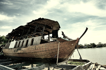 An abandoned wooden boat beside the river