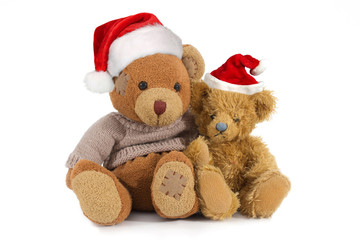 Two, sitting, cuddly stuffed teddy bears in a Santa Claus hat