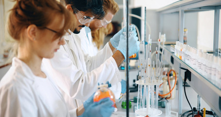 Young students of chemistry working in laboratory