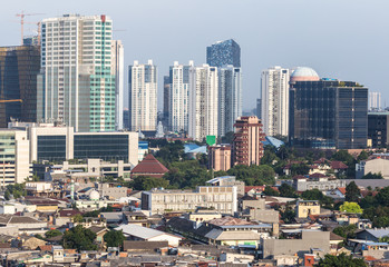 Fototapeta premium Low rise residential district and towers in Jakarta, Indonesia capital city.
