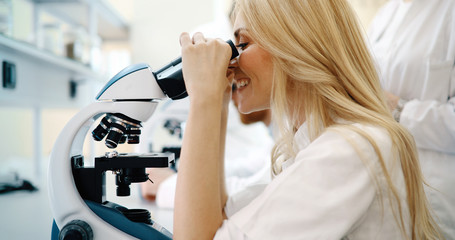 Fototapeta na wymiar Young scientist looking through microscope in laboratory