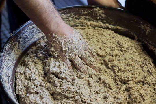hand mixes pork meat for hash
