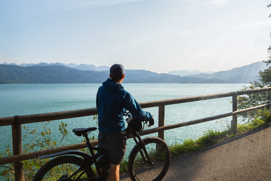Man is riding his e-mountainbike around Walchensee with beautiful view towards Zugspitze in Germany