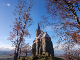 A little stone country church in the beginnings of fall colors.