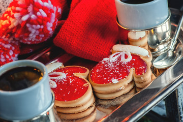 Two of the pie dough mittens and marmalade with black coffee on a cozy Christmas table. Close-up.