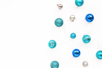 Colorful blue, turquoise, silver christmas balls on white background, flat lay, top view.