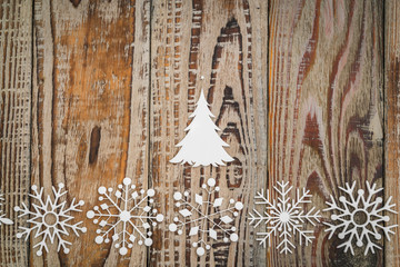 Paper snowflakes on wooden background .