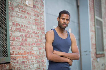 Young handsome African American man in tank top in the rough neighborhood