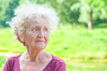 Beautiful sad senior woman in the park