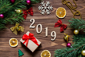 2019 New Year title on the luxurious wooden table surrounded with christmas present, slices of lemon, bells and other christmas tinsel
