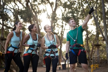 Obraz premium Coach assisting trainee in zip line