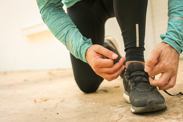 Man tying shoes before running.