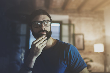 Closeup portrait of Handsome bearded man spending rest time at the modern home at evening.Horizontal. Blurred background.