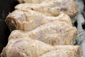 Raw chicken legs in cream sauce prepared for baking or barbecue