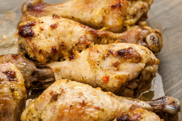 Juicy baked chicken legs with spices closeup shot
