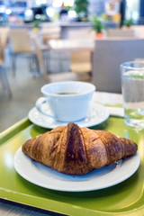 Breakfast with coffee and croissants on table