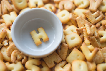 Alphabet biscuit in ceramic cups letters H