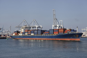 big container ship with cranes in the harbor of rotterdam
