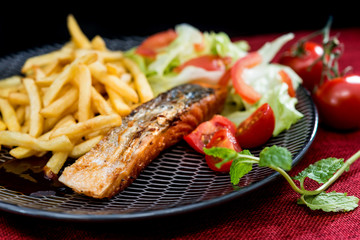 grilled salmon and lemon - french cuisine dish with tomato and salmon