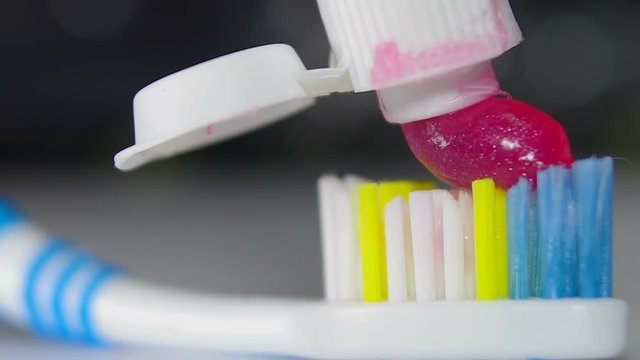 Red toothpaste on a toothbrush (macro)
