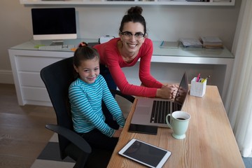 Fototapeta na wymiar Portrait of mother and daughter using laptop