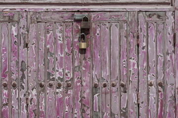 Two rusty padlock locking a wooden door
