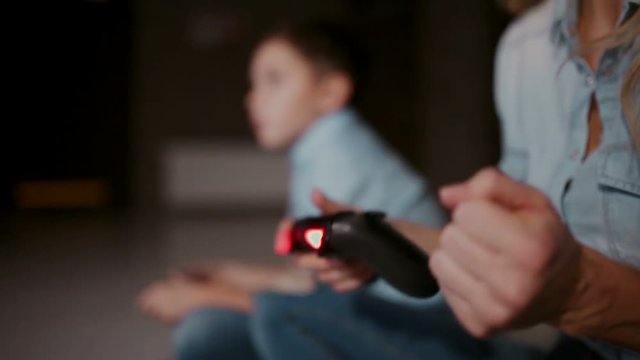 Hands holding a controller to a game console, and in the background the boy looks at the faucet and playing video games. The focus shifts from one to another.