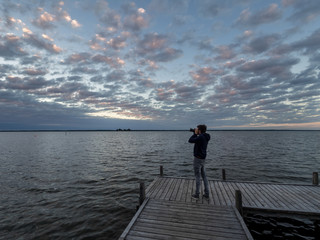 Junger Fotograf auf Steg am See