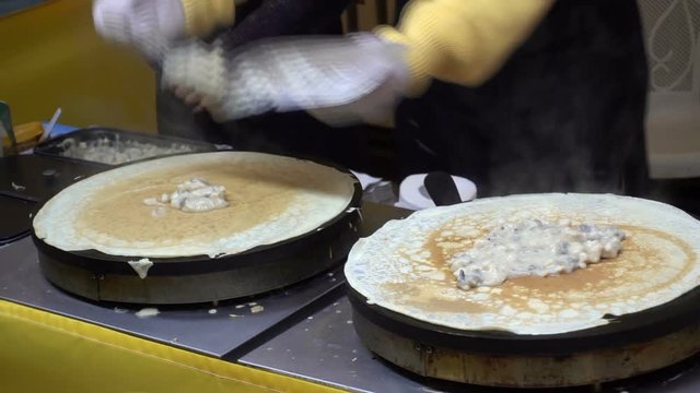 Street food. Cooking of pancakes with filling. The chef puts a different filling in pancakes. HD video clip 