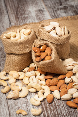 Healthy mix nuts on wooden background. Almonds, hazelnuts, cashews, peanuts, pistachios, brazilian nuts