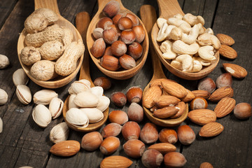 Healthy mix nuts on wooden background. Almonds, hazelnuts, cashews, peanuts, pistachios, brazilian nuts